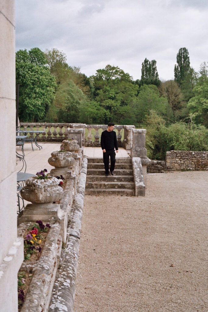 Guest walking along the stone path at Château d'Augerville with garden views