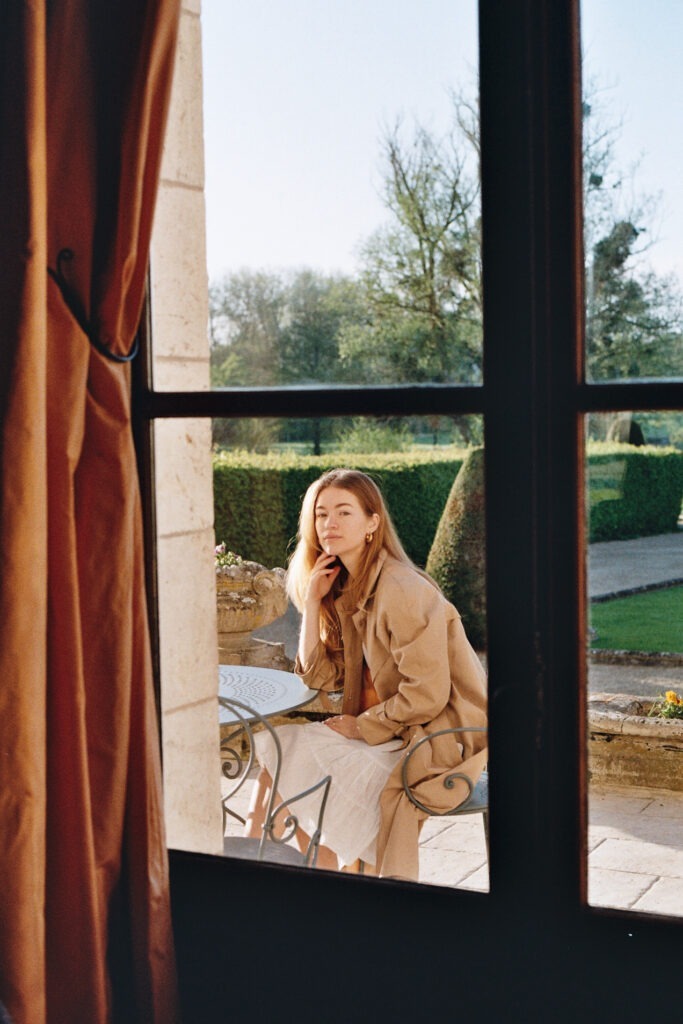 Woman enjoying the view from Château d'Augerville's luxurious hotel room window