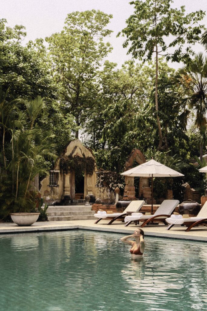 Belmond La Résidence Phou Vao luxury hotel pool area with tropical trees