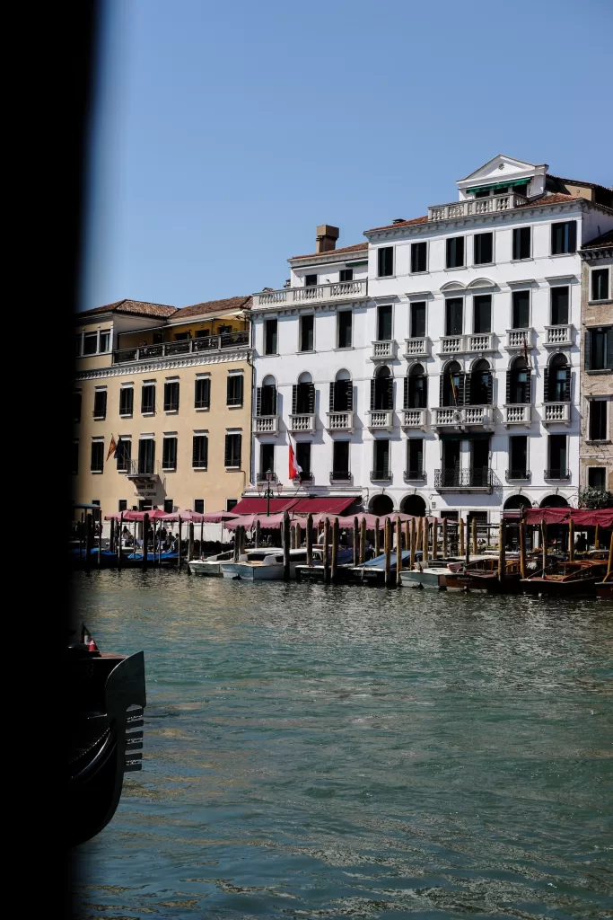 Exterior facade of Violino D’Oro hotel along the Grand Canal in Venice with boats and waterfront view